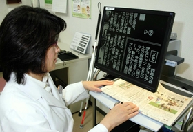 字を見やすくする拡大読書器(モデルは職員)=神戸市中央区港島南町2、先端医療センター病院 字を見やすくする拡大読書器(モデルは職員)=神戸市中央区港島南町2、先端医療センター病院