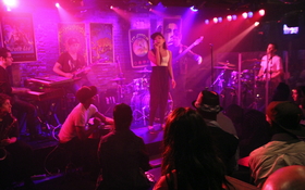 地下のライブハウス。さまざまな人種の観客が彼女を見つめる=ニューヨーク市マンハッタン 地下のライブハウス。さまざまな人種の観客が彼女を見つめる=ニューヨーク市マンハッタン