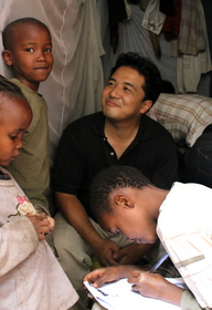 せきが治まったファトマ(右手前)が支援者に手紙を書く。宮田久也(中央)の周りに子どもが集まった=ケニア・ナイロビのキベラ・スラム せきが治まったファトマ(右手前)が支援者に手紙を書く。宮田久也(中央)の周りに子どもが集まった=ケニア・ナイロビのキベラ・スラム