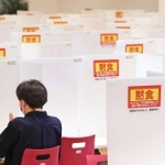 4月下旬から大半の講義が再びオンライン形式に切り替わり、人影がすっかり減った神戸学院大のキャンパス。食堂にぽつんと座る学生が「黙食」を求める張り紙に囲まれていた=5月7日、神戸市中央区港島1