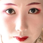 先端が細い「笹眉」を塗るなど伝統の化粧を自ら行うさくらさん。優美な表情から心根の強さも伝わってくる=神戸市北区有馬町
