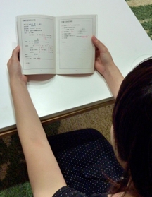 不妊治療を記録した手帳を見る山本良子(仮名) 不妊治療を記録した手帳を見る山本良子(仮名)