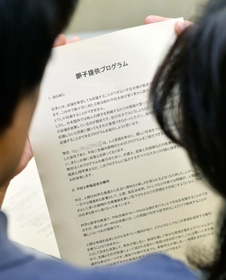 卵子提供エージェンシーの説明資料をのぞき込む美希(右)と夫 卵子提供エージェンシーの説明資料をのぞき込む美希(右)と夫