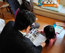 斎藤尚子(仮名)は結衣(仮名)を迎えた日から日記をつけていた。その中に自分の写真を見つけて喜ぶ結衣。「ちっちゃい。これ全部、結衣?」=3月、青森県内の自宅 斎藤尚子(仮名)は結衣(仮名)を迎えた日から日記をつけていた。その中に自分の写真を見つけて喜ぶ結衣。「ちっちゃい。これ全部、結衣?」=3月、青森県内の自宅