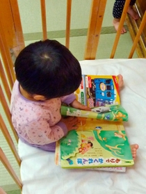 ベビーベッドで絵本を読むユウタ(仮名) ベビーベッドで絵本を読むユウタ(仮名)
