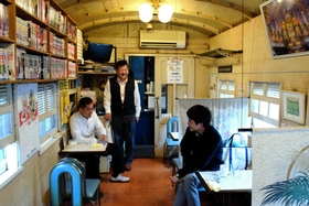 SLの車掌車を改装した店内で常連客と話す店主の岡本正幸さん(中央)=川西市栄町 SLの車掌車を改装した店内で常連客と話す店主の岡本正幸さん(中央)=川西市栄町