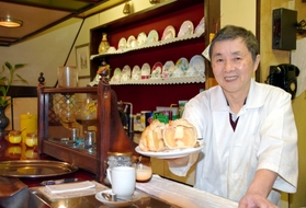 名物アップルパイ「ウィリアム」を持つ王伯郷さん=神戸市中央区元町通3 名物アップルパイ「ウィリアム」を持つ王伯郷さん=神戸市中央区元町通3