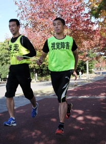 吉住晃一さん(左)の伴走に合わせ、疾走する今井裕二さん=神戸市垂水区名谷町、垂水健康公園 吉住晃一さん(左)の伴走に合わせ、疾走する今井裕二さん=神戸市垂水区名谷町、垂水健康公園
