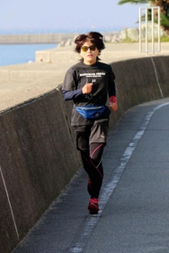 神戸マラソンに向けて、堤防沿いの道を走る山本弥生さん。ウエストポーチとタイツは長女からのプレゼント=明石市大久保町江井島 神戸マラソンに向けて、堤防沿いの道を走る山本弥生さん。ウエストポーチとタイツは長女からのプレゼント=明石市大久保町江井島