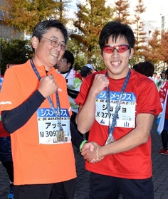 完走し、たたえ合う秋定敦さん(左)と裕人さん=神戸市中央区港島中町6 完走し、たたえ合う秋定敦さん(左)と裕人さん=神戸市中央区港島中町6