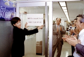 神戸フィルムオフィスが開設し、看板を掲げる田中まこさん=神戸・ポートアイランド(2000年9月13日) 神戸フィルムオフィスが開設し、看板を掲げる田中まこさん=神戸・ポートアイランド(2000年9月13日)
