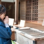 神社で願い事をする女の子(boarder/stock.adobe.com)