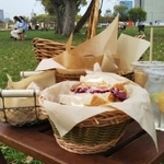 ピクニックを楽しむ人々の向こうにかすかに見える大阪城