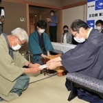 立会人の淡路仁茂九段(左)に封じ手が入った封筒を渡す木村一基王位(右)。中央は藤井聡太棋聖=4日午後、神戸市北区有馬町、旅館「中の坊瑞苑」(撮影・斎藤雅志)