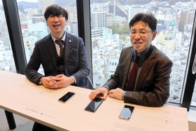 スマホを置くだけで充電できるスマートテーブルで協議する池内さん(右)と神納さん=アンカー神戸 スマホを置くだけで充電できるスマートテーブルで協議する池内さん(右)と神納さん=アンカー神戸