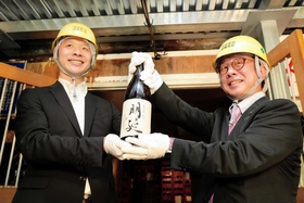 蔵出しした純米酒「明延」を掲げる(左から)山陽盃酒造の壺阪雄一専務と大林賢一養父市長=養父市大屋町明延 蔵出しした純米酒「明延」を掲げる(左から)山陽盃酒造の壺阪雄一専務と大林賢一養父市長=養父市大屋町明延