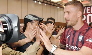 サポーターとタッチしながら会場を後にするルーカス・ポドルスキ=神戸ポートピアホテル(撮影・西岡正)