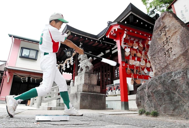 素振り奉納。視線の先には、元阪神監督の岡田彰布さんが揮毫(きごう)した野球塚がある=西宮市甲子園町、甲子園素盞嗚神社(撮影・吉田敦史) 素振り奉納。視線の先には、元阪神監督の岡田彰布さんが揮毫(きごう)した野球塚がある=西宮市甲子園町、甲子園素盞嗚神社(撮影・吉田敦史)