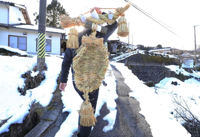 できあがったコトノハシを背負い、雪道を歩く村人。草履は男性の背中ほど大きい=養父市長野(撮影・大山伸一郎) できあがったコトノハシを背負い、雪道を歩く村人。草履は男性の背中ほど大きい=養父市長野(撮影・大山伸一郎)