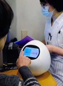 患者(手前)に白内障手術の準備について説明するロボット「パラメディ・タピア」=明石市朝霧台、あさぎり病院 患者(手前)に白内障手術の準備について説明するロボット「パラメディ・タピア」=明石市朝霧台、あさぎり病院