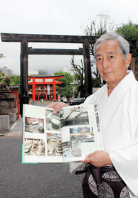 86年の役目を終えた鳥居を背に、阪神・淡路大震災の記録集を手にする六車勝昭宮司=いずれも神戸市中央区下山手通1、生田神社 86年の役目を終えた鳥居を背に、阪神・淡路大震災の記録集を手にする六車勝昭宮司=いずれも神戸市中央区下山手通1、生田神社