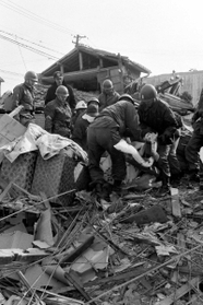 がれきの中から遺体を運び出す自衛隊員=1995年1月18日午前、神戸市長田区御船通 がれきの中から遺体を運び出す自衛隊員=1995年1月18日午前、神戸市長田区御船通