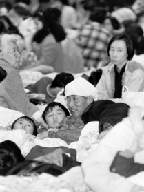 多くの近隣住民が避難した安井小学校の体育館。カメラに気付いた何人かが視線を向けた=1995年1月17日、西宮市安井町 多くの近隣住民が避難した安井小学校の体育館。カメラに気付いた何人かが視線を向けた=1995年1月17日、西宮市安井町