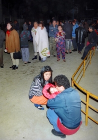 最初に駆け込んだ公園には大勢の人たちが避難していた。小さな子どもをしっかりと抱き寄せ、かがみ込んでいる男性がいた=1995年1月17日午前6時ごろ、神戸市兵庫区佐比江町、佐比江公園 最初に駆け込んだ公園には大勢の人たちが避難していた。小さな子どもをしっかりと抱き寄せ、かがみ込んでいる男性がいた=1995年1月17日午前6時ごろ、神戸市兵庫区佐比江町、佐比江公園