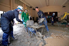 昨年7月の九州豪雨の被災地で、集会施設にたまった泥を運び出すボランティア 昨年7月の九州豪雨の被災地で、集会施設にたまった泥を運び出すボランティア