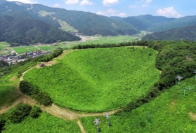 夏は緑、冬は銀世界に染まる神鍋山噴火口。後方の山の斜面は奥神鍋スキー場(小型無人機より撮影)=豊岡市日高町栗栖野 夏は緑、冬は銀世界に染まる神鍋山噴火口。後方の山の斜面は奥神鍋スキー場(小型無人機より撮影)=豊岡市日高町栗栖野