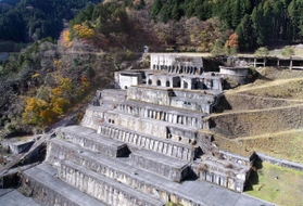 建屋が撤去され、基礎部分が階段のように残る。そばの斜面にあるインクラインのレールで各フロアに人や物を運んだ(小型無人機より撮影)=朝来市佐嚢 建屋が撤去され、基礎部分が階段のように残る。そばの斜面にあるインクラインのレールで各フロアに人や物を運んだ(小型無人機より撮影)=朝来市佐嚢
