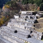 建屋が撤去され、基礎部分が階段のように残る。そばの斜面にあるインクラインのレールで各フロアに人や物を運んだ(小型無人機より撮影)=朝来市佐嚢
