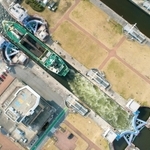 長さ90メートルの閘室を通過して大阪湾へ向かう砂利運搬船。交通量の多い日は2基の閘門がフル稼働する(小型無人機で撮影)=尼崎市西海岸町