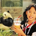 王子動物園名物「パンダと一緒・ミックスジュース」パンダのエサ、笹、リンゴ、ニンジンを素材にしたジュースを手に写真に収まる女の子=2004年9月、神戸市灘区、市立王子動物園