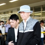 爆発物取締罰則違反などの容疑で逮捕され、新幹線で移送された関孝司容疑者(中央右)=14日午後4時59分、JR新神戸駅