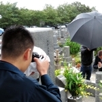墓参りに訪れた山口組最高幹部の姿を、写真撮影する兵庫県警の捜査員=20日午前、神戸市灘区