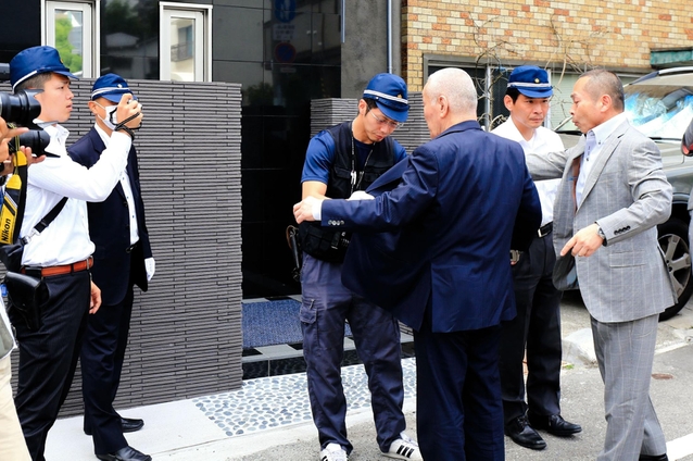 神戸山口組の会合に集まる組員のボディーチェックをする捜査員=神戸市中央区二宮町3