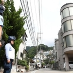 防弾チョッキを着た警察官が警戒し、現場周辺は一夜明けても物々しい雰囲気に=22日午前10時20分、神戸市中央区熊内町9