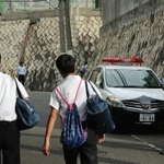 登校する中学生を見守る警察官=27日午前、神戸市中央区