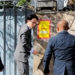 山口組の総本部で、使用制限を示す「標章」を仮命令用から本命令用に張り替える兵庫県警の警察官=15日、神戸市灘区篠原本町4