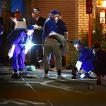射殺事件があった現場付近を調べる兵庫県警の捜査員=27日夜、尼崎市神田南通1