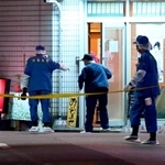 射殺事件があった現場付近を調べる兵庫県警の捜査員=27日夜、尼崎市神田南通1