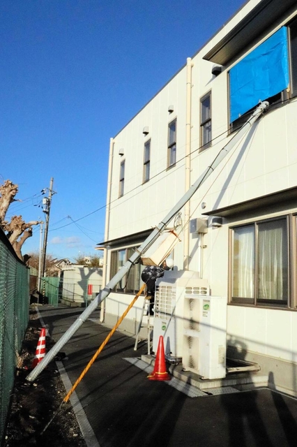 強風で折れたとみられる電柱。コミセンの窓ガラスが割れる被害があった＝明石市東人丸町