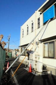 強風で折れたとみられる電柱。コミセンの窓ガラスが割れる被害があった＝明石市東人丸町