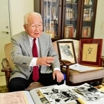 原人まつりの資料を手に思い出を振り返る山根金造さん＝明石市