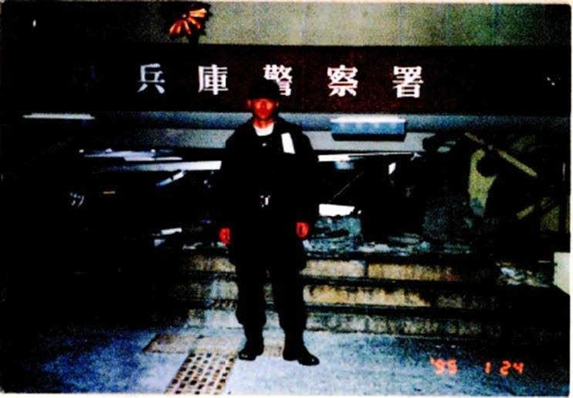 当直中に生き埋めになった兵庫署前に立つ文野長生さん＝１９９５年１月２４日、神戸市兵庫区（明石署提供）
