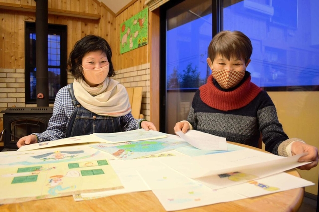 アマビエの絵本の原画を見ながら絵本の装丁について話し合う中野愛子さん（左）と岡本米子さん＝明石市大久保町西脇