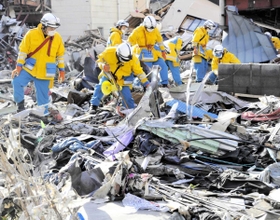 がれきの中で行方不明者を捜索する兵庫県警の警察官＝２０１１年３月、岩手県釜石市