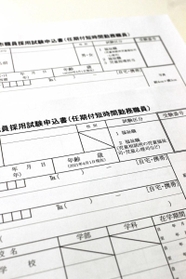 市職員の採用試験申込書。新しい書類（手前）では性別欄が斜線で削除されている＝明石市役所