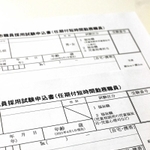 市職員の採用試験申込書。新しい書類（手前）では性別欄が斜線で削除されている＝明石市役所